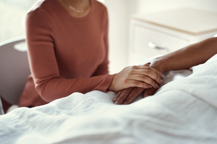 Cancer, healthcare and support with a woman holding hands with her man in the hospital. Medicine, insurance and trust with a couple in a clinic for treatment or help before death, mourning and loss